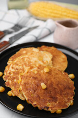 Tasty corn pancakes in plate on table, closeup