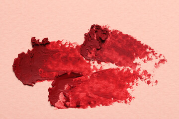 Smears of red lipstick on light background, top view