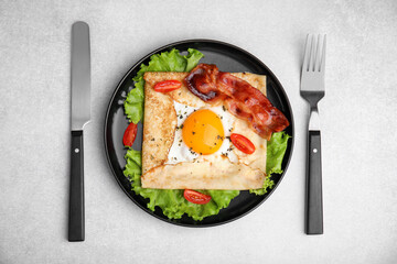 Delicious crepe with egg on light gray table, top view. Breton galette