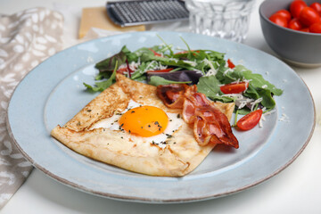 Delicious crepe with egg on white table. Breton galette