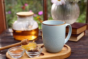 Tray with delicious tea and ingredients on wooden table, closeup