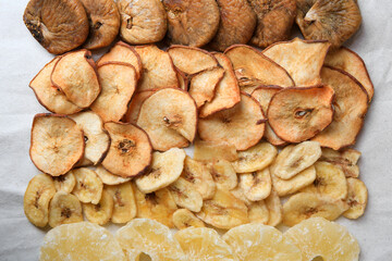 Different tasty dried fruits on paper, flat lay