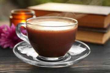 Glass cup with coffee on wooden table, closeup. Morning ritual