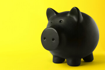 Ceramic piggy bank on yellow background. Space for text