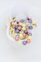White bathtub full of colorful beads and foam decorations. Top view. Copy space. Close up
