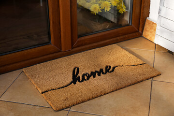 Doormat with word Home near entrance outdoors