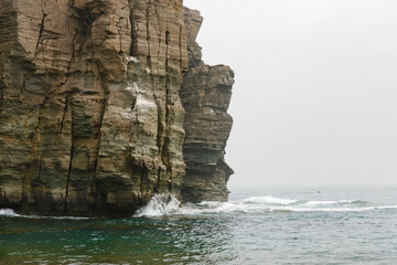 Rocky cliffs waves of the sea are clogged against the rocks
