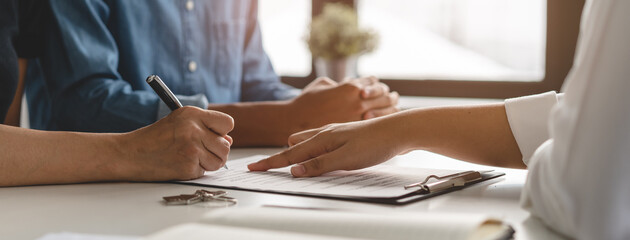 financial investor advisory.  Close up hand pointing at contract and document while sitting...