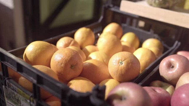 Two Fruit Boxes On Top Of A Shop Stand Full Of Oranges And Apples