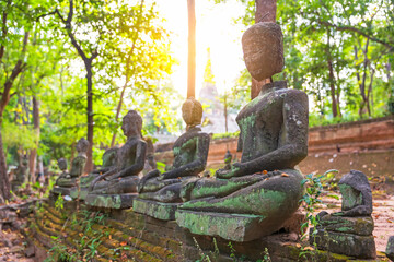 Many of old buddha statues wreckage with green forest nature in Wat Umong at Chiang Mai of Thailand