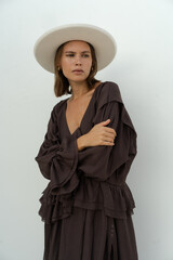 Studio photo of fashionable  woman in stylish  hat and elegant casual dress posing ower white...