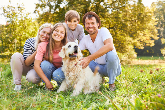 Glückliche Familie mit zwei Kindern und Hund im Park
