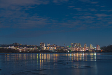 Scenic view of the city of Dnepr in the winter evening. Dnipro in the evening. Ukrainian city in winter at night. background image. Panoramic view. Long exposure photo of the Dnieper River at night.