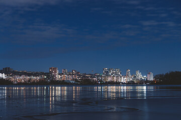 Fototapeta premium Scenic view of the city of Dnepr in the winter evening. Dnipro in the evening. Ukrainian city in winter at night. background image. Panoramic view. Long exposure photo of the Dnieper River at night.