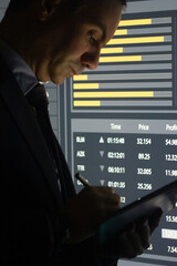 Close-up of financier planning profit for company. Concentrated man analyzing market currency data calculating index to get profit. Market trading, investment activity concept - obrazy, fototapety, plakaty