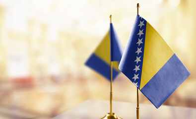 Small flags of the Bosnia and Herzegovina on an abstract blurry background