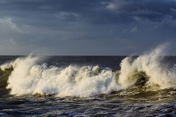 violent steep waves crashing onto a sandy beach during winter. Shot in Denmark