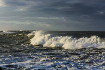 violent steep waves crashing onto a sandy beach during winter. Shot in Denmark