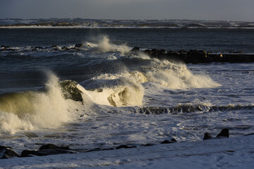 violent steep waves crashing onto a sandy beach during winter. Shot in Denmark