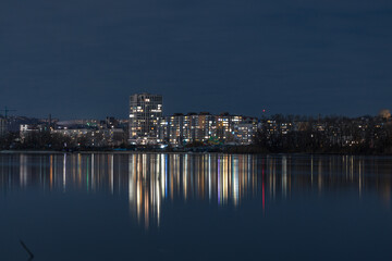 Fototapeta premium Scenic view of the city of Dnepr in the winter evening. Dnipro in the evening. Ukrainian city in winter at night. background image. Panoramic view. Long exposure photo of the Dnieper River at night.