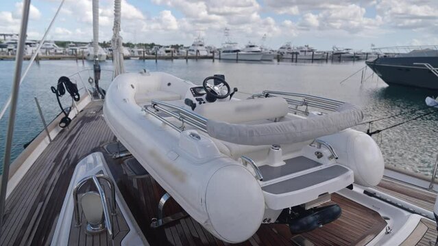 Tender on foredeck of Oyster 82 luxury sailboat moored in port. High angle