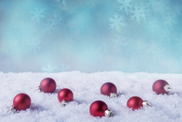 Red Christmas balls in snow over abstract holiday background with copy space. Christmas and New...
