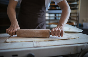 Close-up of young baker preparing pastries in bakery.