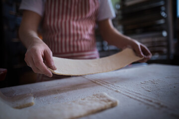 Close-up of baker preparing pastries in bakery.