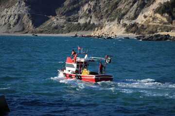 Fototapeta premium Red fishing boat on Mediterranean sea. Blue sea and sunny day. 