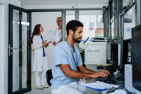 Young doctor working on computer in his office.
