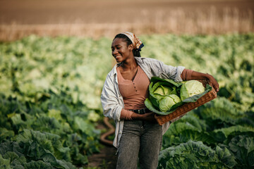 Shot of an attractive young female farmer carrying a crate of fresh produce.