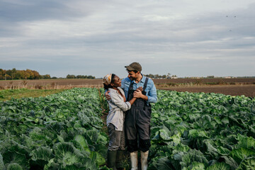 Portrait of a loving working couple standing on their field on the farm, proud of what they accomplished. Small business concept