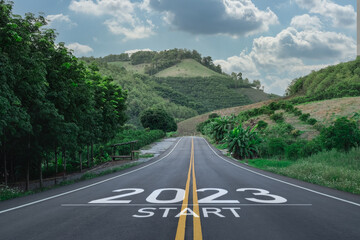 Happy new year 2023,2023 symbolizes the start of the new year. The letter start new year 2023 on the road in the nature route roadway have tree environment ecology or greenery wallpaper concept. - obrazy, fototapety, plakaty