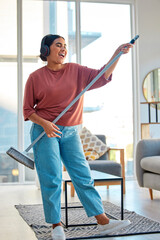 Fototapeta na wymiar Woman, headphones and cleaning living room with music for home spring cleaning, housekeeping or sweeping floor. Singing karaoke, online podcast and happy cleaner or housework with broom in apartment
