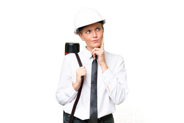Young architect caucasian woman with helmet and holding blueprints over isolated background having...