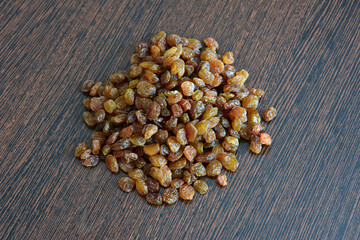 heap of dry sultana on dark wooden background isolated, close-up