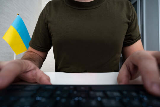 male soldier in a military uniform is sitting at a computer. center for special military psychological operations. The concept of information warfare. - Powered by Adobe