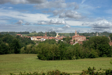 Cityscape of Bene Vagienna, Cuneo, Piedmont, Italy, with view landscape of the castle and the ancient bell towers between green fields and woods
