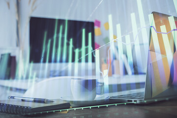 Stock market graph on background with desk and personal computer. Double exposure. Concept of financial analysis.