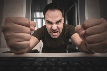 freelancer punches the keyboard. angry man swearing and cursing against information technology and...