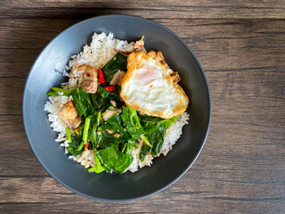 Crispy pork with Chinese broccoli and oyster sauce on rice and fried egg