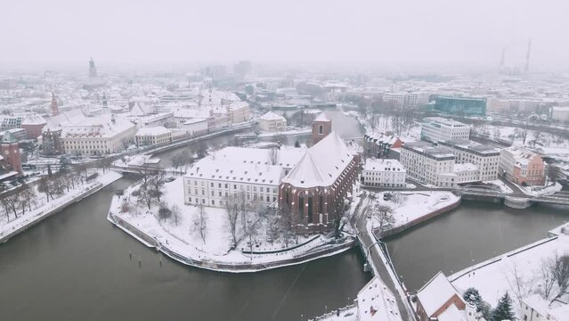 Winter aerial view with snowfall on Roman Catholic parish church NMP on the Sand in Wroclaw 4k