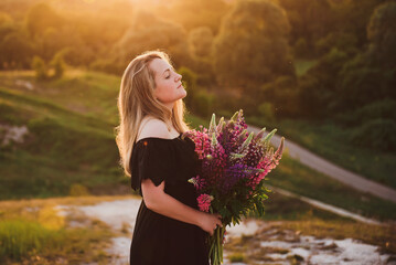 woman with a bouquet of flowers at sunset
