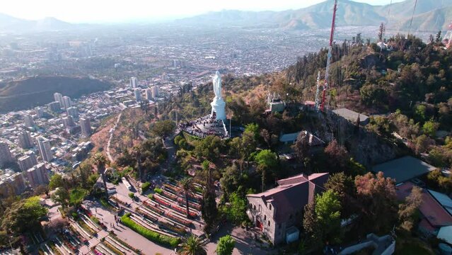 Tilt up aerial view of the Sanctuary of the Virgin of Cerro San Cristobal on a sunny day, tourist spot of the city, viewpoint. Santiago, Chile