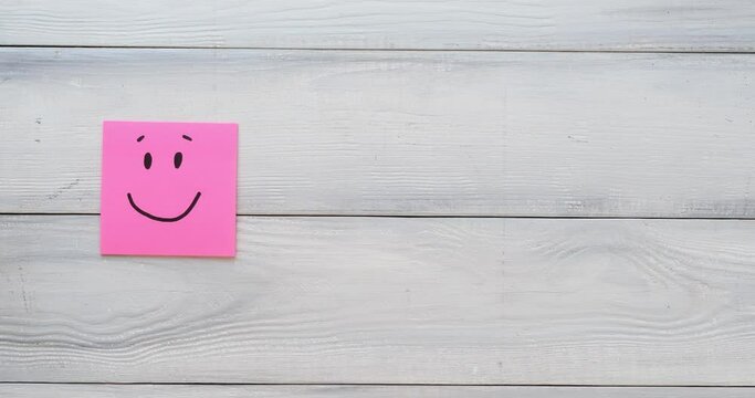 Basic emotions are joy, sadness, anger, fear or surprise. Four colorful squares with emotions on a white wooden background. 4K looped stop motion animation