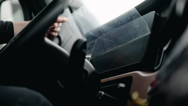 close up driver peeling plastic screen protector of a freightliner cascadia volvo 2023.