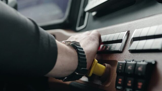 Truck driver pushing with hand parking break knob of a new freightliner cascadia volvo 2023.No face