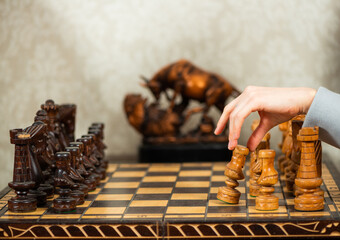 lady making first move with white wooden pawn in chess game at vintage living room interior - 554867172