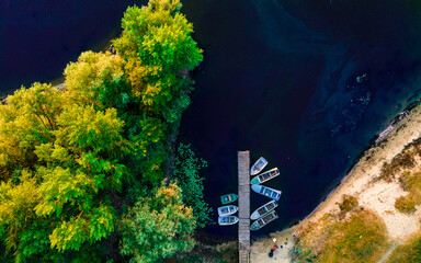 Aerial top down view of river pier with boats in summer at sunset