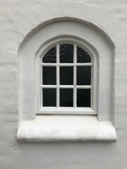 window in the old, white brick wall
